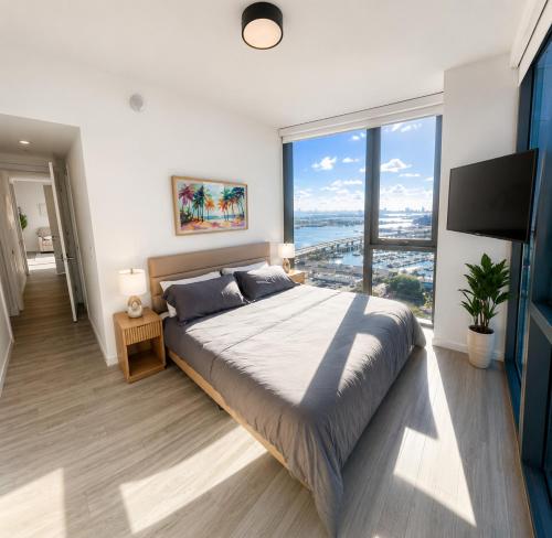 a bedroom with a large bed and a large window at The Downtown Luxury Collection in Miami