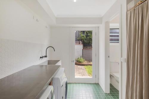a kitchen with a sink and a green tile floor at Wild Views in Tathra