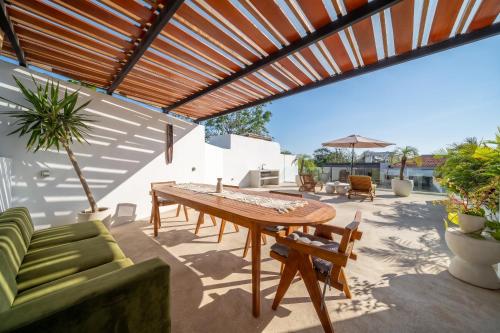 a patio with a wooden table and chairs at Darina Villa - Private Rooftop Escape with Pool Close to Beach in Badung