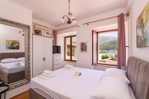a bedroom with a bed and a mirror at Apartments and rooms by the sea Slano, Dubrovnik - 2687 in Slano