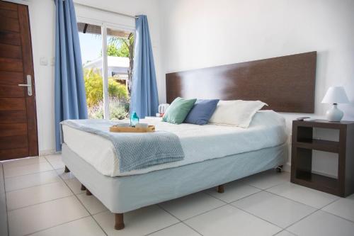a bedroom with a bed with a wooden headboard and a window at Hotel Mar y Arte in Piriápolis