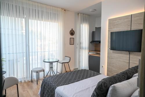 a hotel room with a bed and a table and a television at Hana boutique apartments in Ulcinj