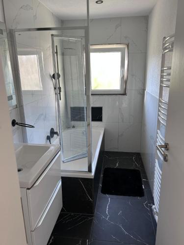 a bathroom with a shower and a tub and a sink at Ferienwohnung Nordheim in Nordheim