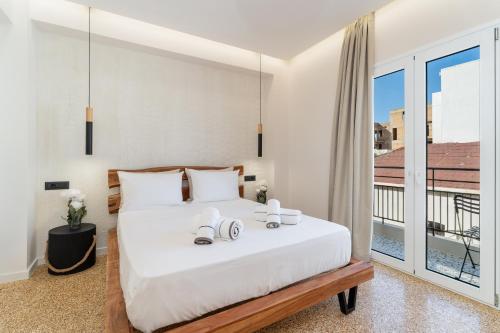 a bedroom with a bed and a large window at Maistrali city suites in Agios Nikolaos