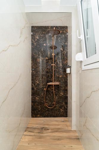 a shower in a bathroom with a wall at Maistrali city suites in Agios Nikolaos