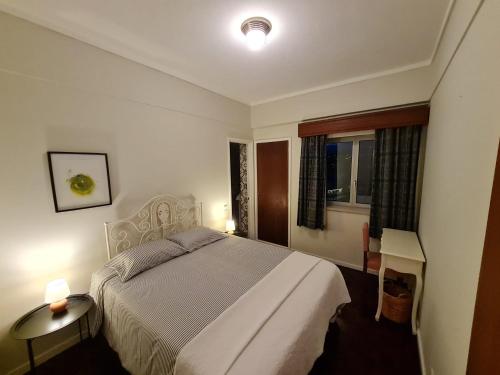 a bedroom with a bed and a desk and a window at SolMar View Apartment, Azores in Ponta Delgada