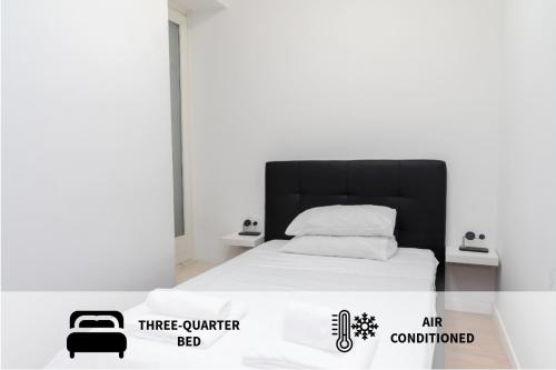 a white bed with a black headboard in a room at Piazza Duomo Cathedral View in Brescia
