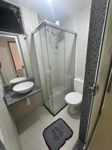 a bathroom with a shower and a toilet and a sink at Apartamento no Centro in Muriaé