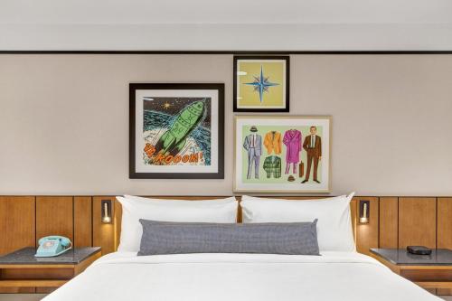 a bedroom with a white bed and pictures on the wall at Hotel Indigo - Minneapolis Downtown by IHG in Minneapolis