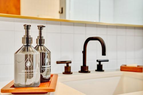 two bottles of alcohol sitting on a counter next to a sink at Hotel Indigo - Minneapolis Downtown by IHG in Minneapolis