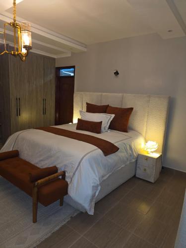 a bedroom with a large bed in a room with a light at Jaymorgan Villas 4 bedroomed in Nanyuki