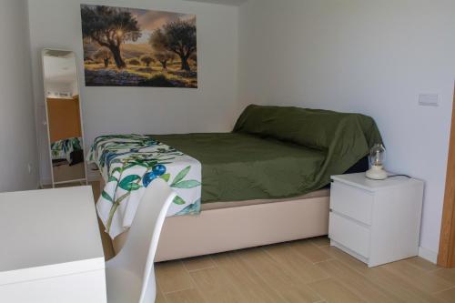 a small bedroom with a bed with a green comforter at Casa da Quinta da Azeitona 2 - Piscina privada e BBQ na Serra da Gardunha in Fundão