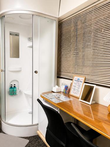 a office with a desk and a shower and a table at Lee Ryokan Tokyo in Tokyo