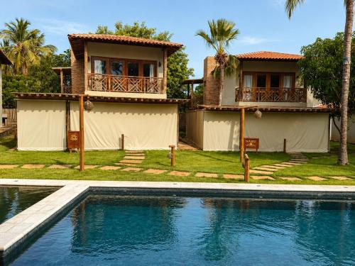 a house with a swimming pool in front of a house at Casa Naru in Atins
