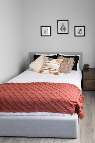 a bed with a red blanket and pillows on it at Down East Cabins Ltd in Tracadie