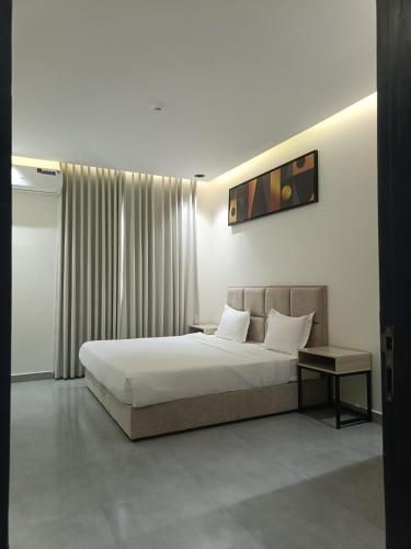 a bedroom with a large bed and a table at منتجع هدب للشقق المخدومة in Taif