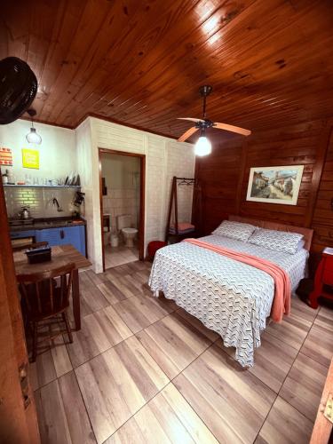 a bedroom with a bed and a table and a sink at Recanto do Zeca Morretes in Morretes