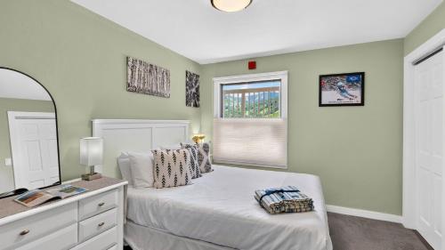 a bedroom with a white bed and a window at Serenity by the Slopes in Vail