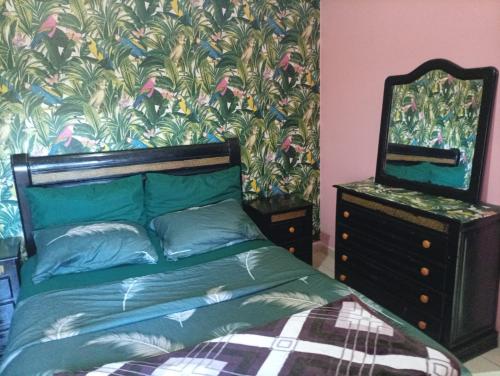 a bedroom with a bed with a dresser and a mirror at الصخيرات in Skhirat