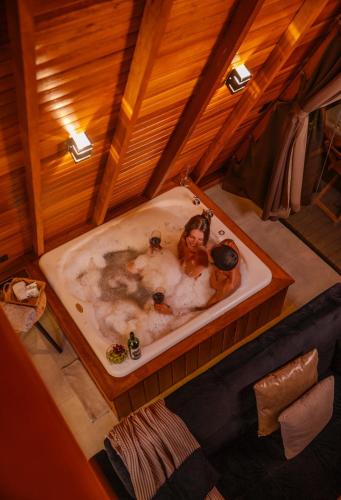 two people in a bath tub in a room at Cabana com banheira in Gramado