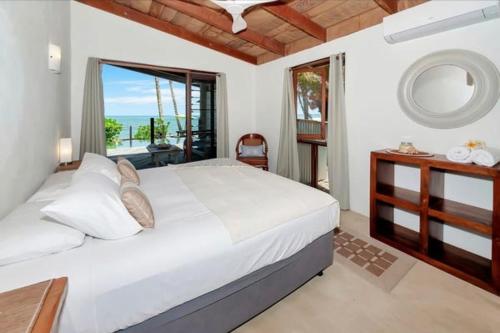 a bedroom with a bed with a view of the ocean at Boonooloo on Absolute Beachfront in Newell Beach