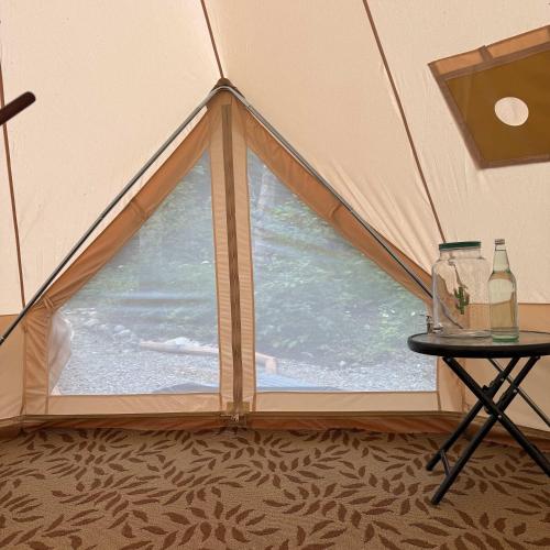 a tent with a small table and a window at Willowbank Bell Tent in Golden