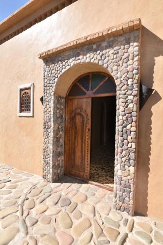 an entrance to a building with a wooden door at Serdrar Camp in Timganine