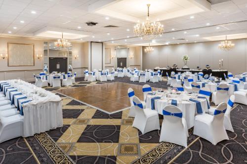 a banquet hall with white tables and chairs at Wyndham Garden Greensboro in Greensboro
