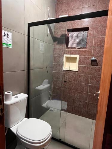 a bathroom with a toilet and a glass shower at Loft 4 Mobiliado e Individual com Garagem 3min do centro in Dourados