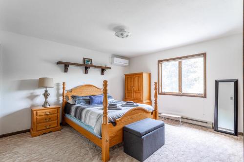 a bedroom with a wooden bed and a window at Rustic Mountain view Cabin 5 mins to Ski Area! in Windham