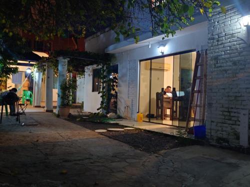 a man sitting in a chair in a window at night at Hostel Chaton in Asunción