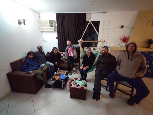 a group of people sitting in a living room at Hostel Chaton in Asunción