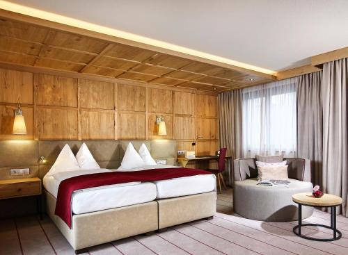 Pokój hotelowy z dużym łóżkiem i krzesłem w obiekcie Hotel Innsbruck w mieście Innsbruck