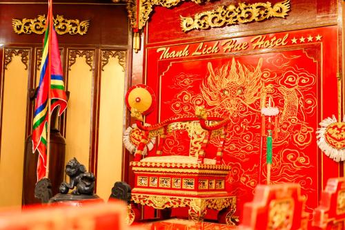 a red room with a golden chair and a flag at Thanh Lich Royal Boutique in Hue