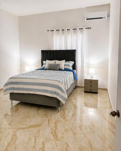 a bedroom with a large bed and a wooden floor at Alojamiento en Miches in Miches