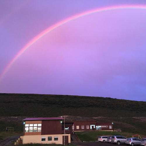 a rainbow in the sky over a building at Vestmannsvatn Guesthouse in Aðaldalur