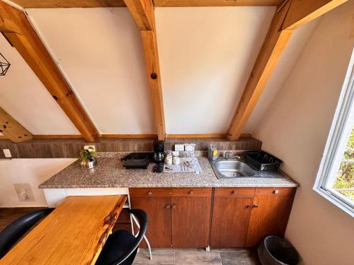 a small kitchen with a sink and a wooden table at La cabaña del jaguar in Tepoztlán