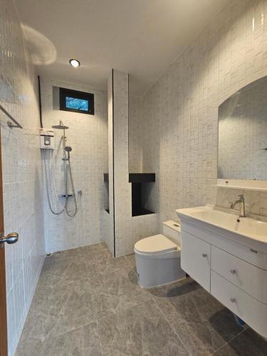 a bathroom with a toilet and a sink and a shower at Anda Sea view in Klong Muang Beach