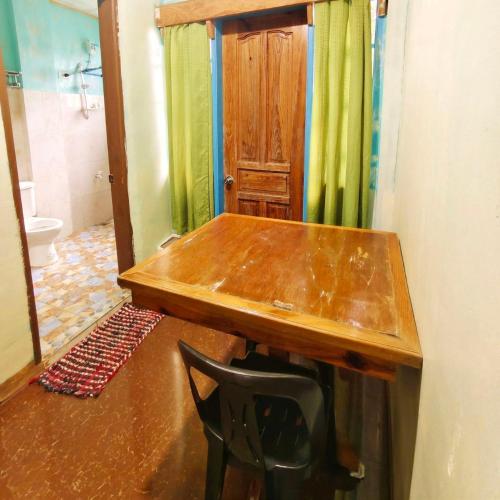 a wooden table and a chair in a bathroom at Mountain Lodge within Town Proper! in Sagada