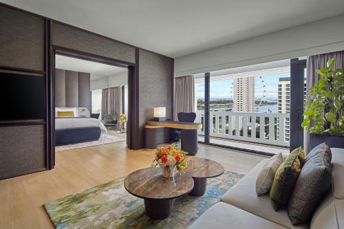 a hotel room with a bed and a living room at PARKROYAL COLLECTION Marina Bay, Singapore in Singapore