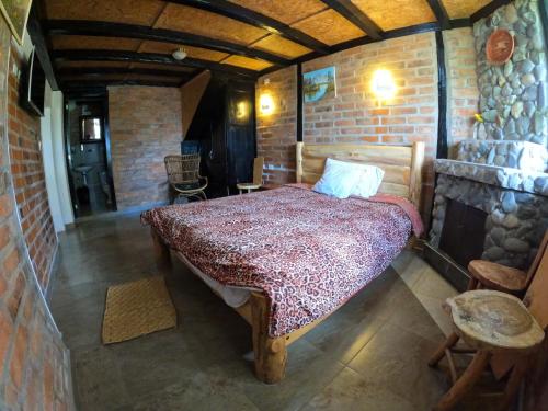 a bedroom with a bed in a brick wall at Hosteria Chyrywasy Home in Ibarra