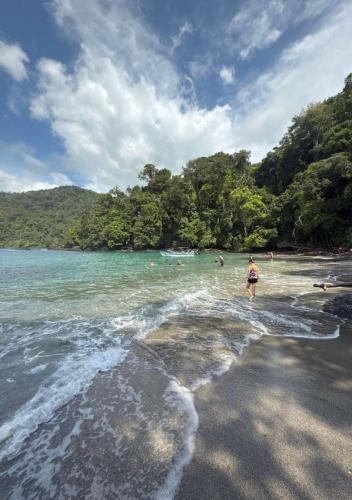 a person standing on a beach near the water at Playa Verde Lodge in Bahía Solano