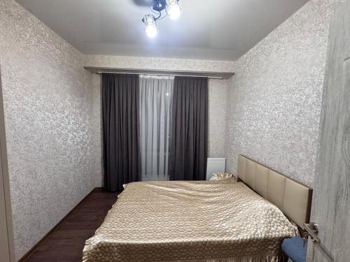 a bedroom with a bed and a large window at Nadikvari in Tbilisi City