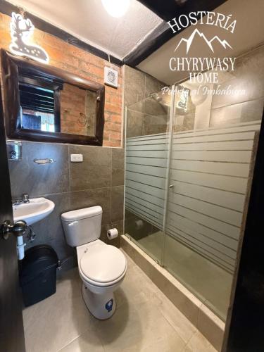 a bathroom with a toilet and a shower and a sink at Hosteria Chyrywasy Home in Ibarra