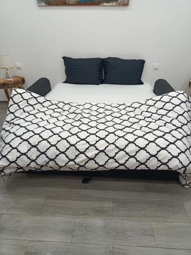 a bed with a black and white comforter at Elegant Studio - Ideal for Couples in Mazagran