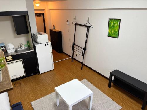 a living room with a white table and a refrigerator at アルゴ境川 in Kitakyushu