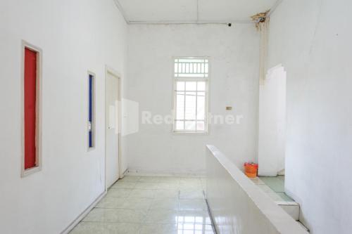 an empty room with white walls and a window at Ombai Guest House 27 Syariah Mitra RedDoorz in Kertapati