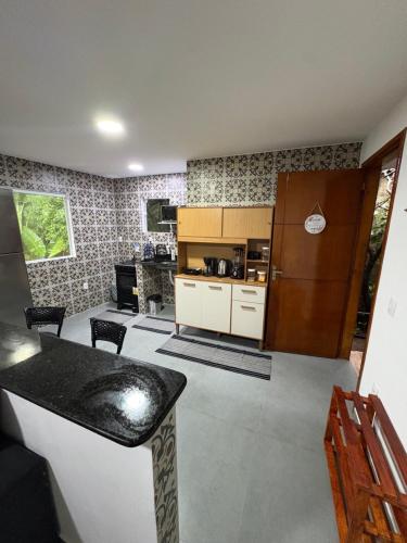 a room with a kitchen with a counter and a refrigerator at Apartamento com vista e privacidade , ideal para casais , próximo da praia in Rio de Janeiro