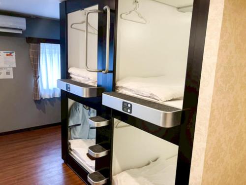 a room with two bunk beds and a mirror at ホテルリブマックスBudget川崎大師 in Kawasaki