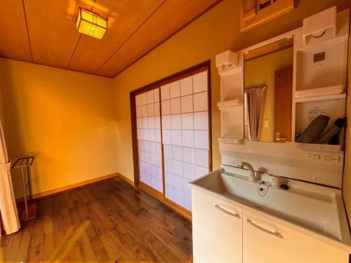 a kitchen with yellow walls and wooden floors at Yufuin Ryokan Yufumomiji in Yufu